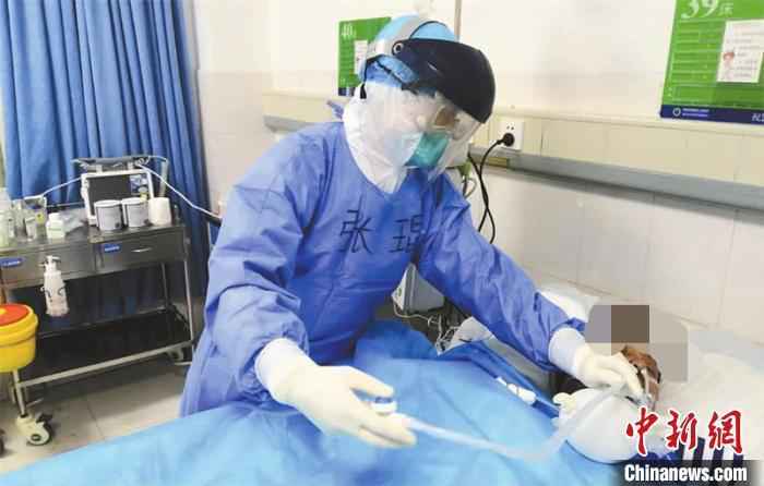 资料图:医护人员精心照料躺在病床上的诸某。张驰 摄 新冠肺炎ICU病房医生:生死时刻,和患者几乎口鼻相对